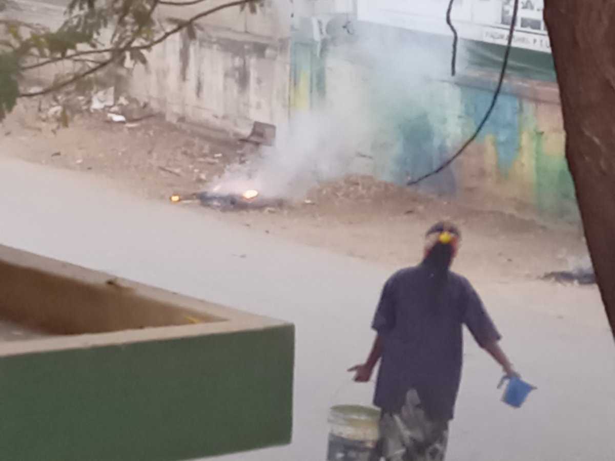 Panchampagadam's tweet photo. Ballari is perhaps one of the most poorly rated city corporations in the country. Apart from sweeping only once in blue moon, they even set the trash on fire, causing pollution. I had to warn this lady before she doused it. Officials don't ever bother to even check @BellaryNamma https://t.co/KbaFLD5Cek