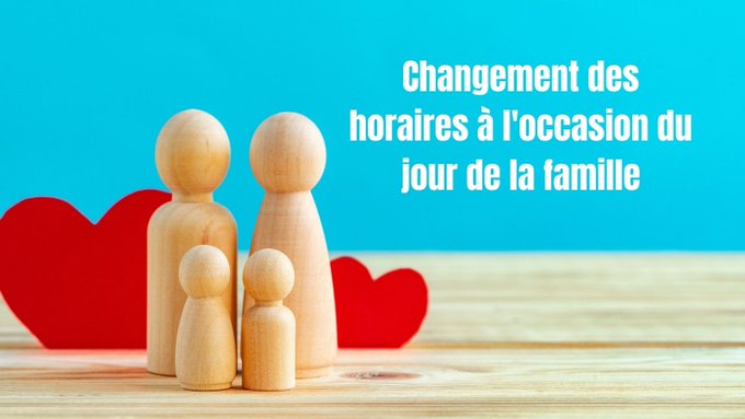 Une photo de quatre sculptures en bois en forme de personnes avec deux cœurs rouges en arrière-plan. Un texte blanc indique « Changements des horaires à l'occasion du jour de la famille »