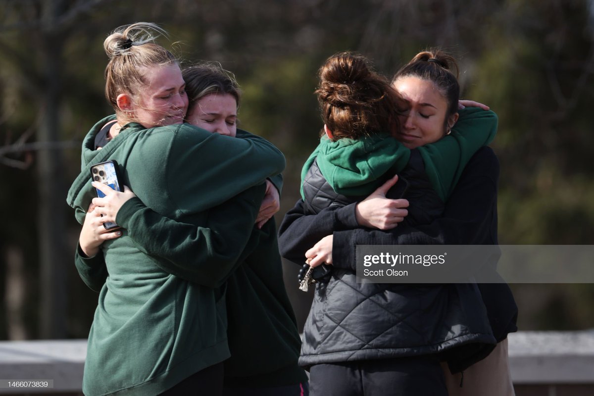 People visit a memorial on the 5th anniversary of the #MarjoryStonemanDouglas mass shooting in #Parkland, FL today while others embrace on the campus of #MichiganStateUniversity after a mass shooting there last night.
📸: @saulmartnez, 
@olsongetty #StonemanDouglas #MSU