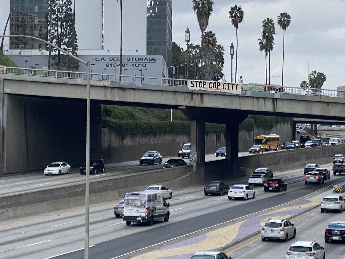 Banner drop today over the 110 in downtown LA with @PplsCityCouncil in solidarity with #StopCopCity @defendATLforest