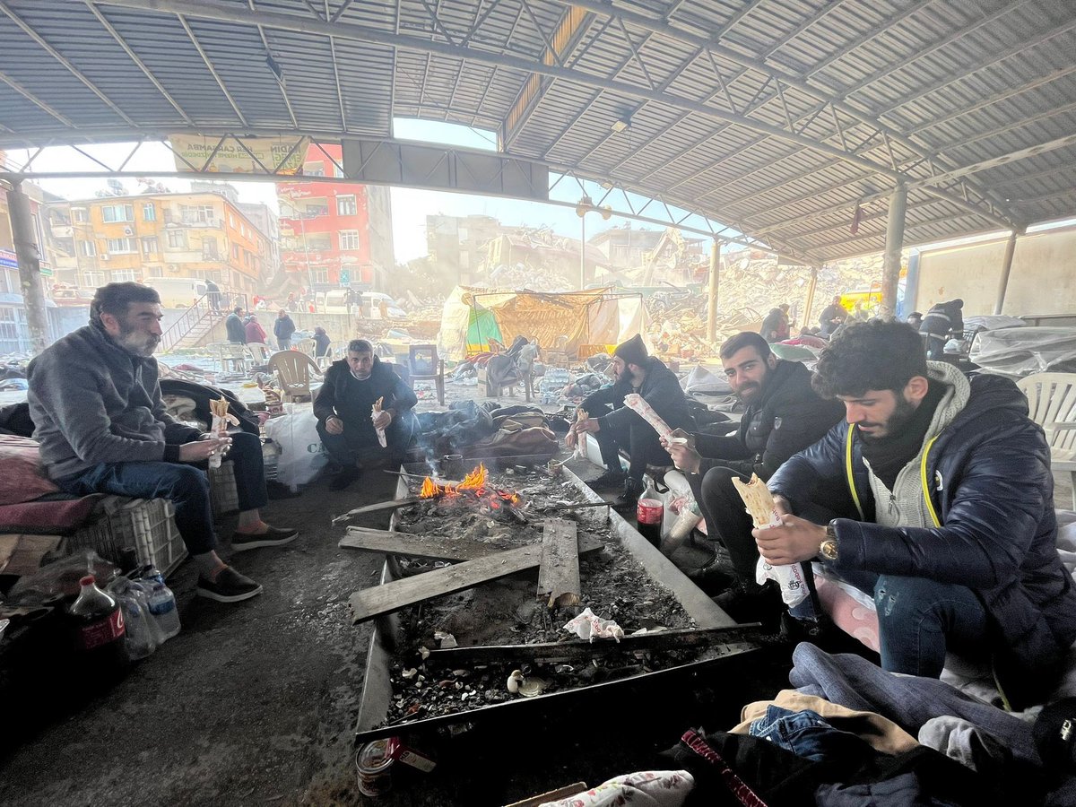 Pictured behind this group of men are their homes, now destroyed by the earthquake. The city center in Antakya is one of many places WCK distributed 2,000 kebabs &amp; sausage rolls in Hatay Province. Many hadn't eaten a full meal &amp; were happy to receive protein! #ChefsForTürkiye