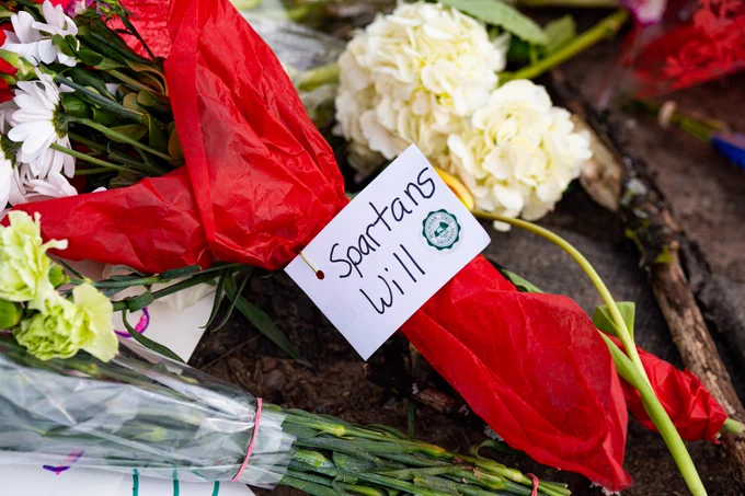 Several bouquet of flowers, with one bouquet wrapped in red and a tag that says Spartans Will