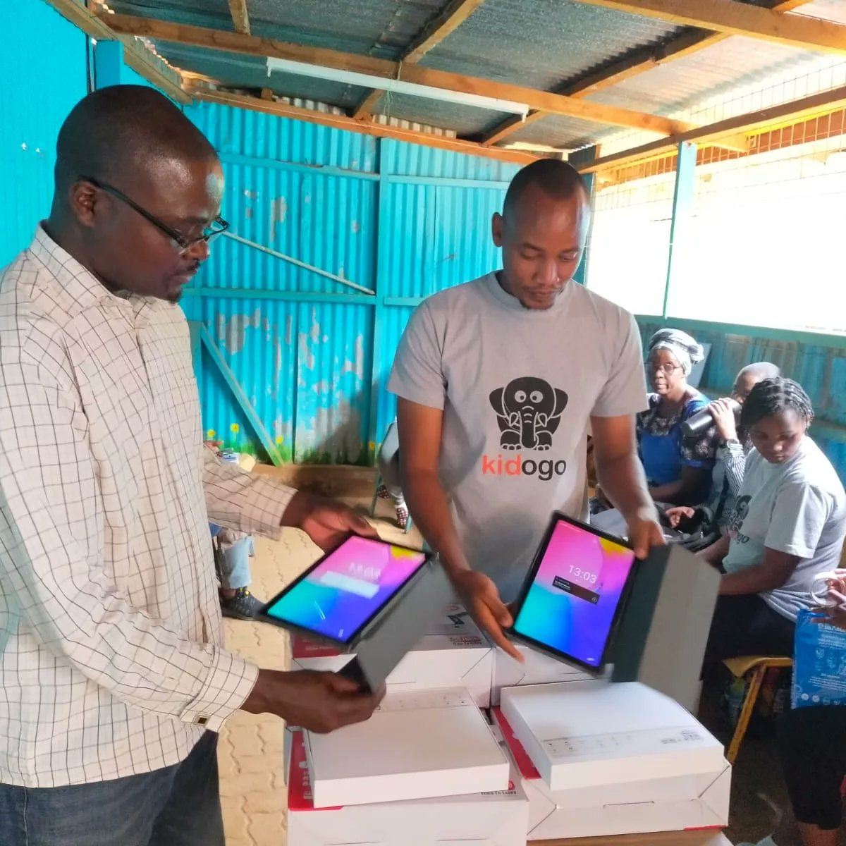 Worldreader's Associate director of programs East Africa, Peter Clavers Otieno alongside Program manager, Austin Okoth handing over tablets and projectors to <a href="/Kidogo_ECD/">Kidogo</a>  to support digital reading to targeted reading communities in Nairobi under the Cheza Soma Jifunze project.
