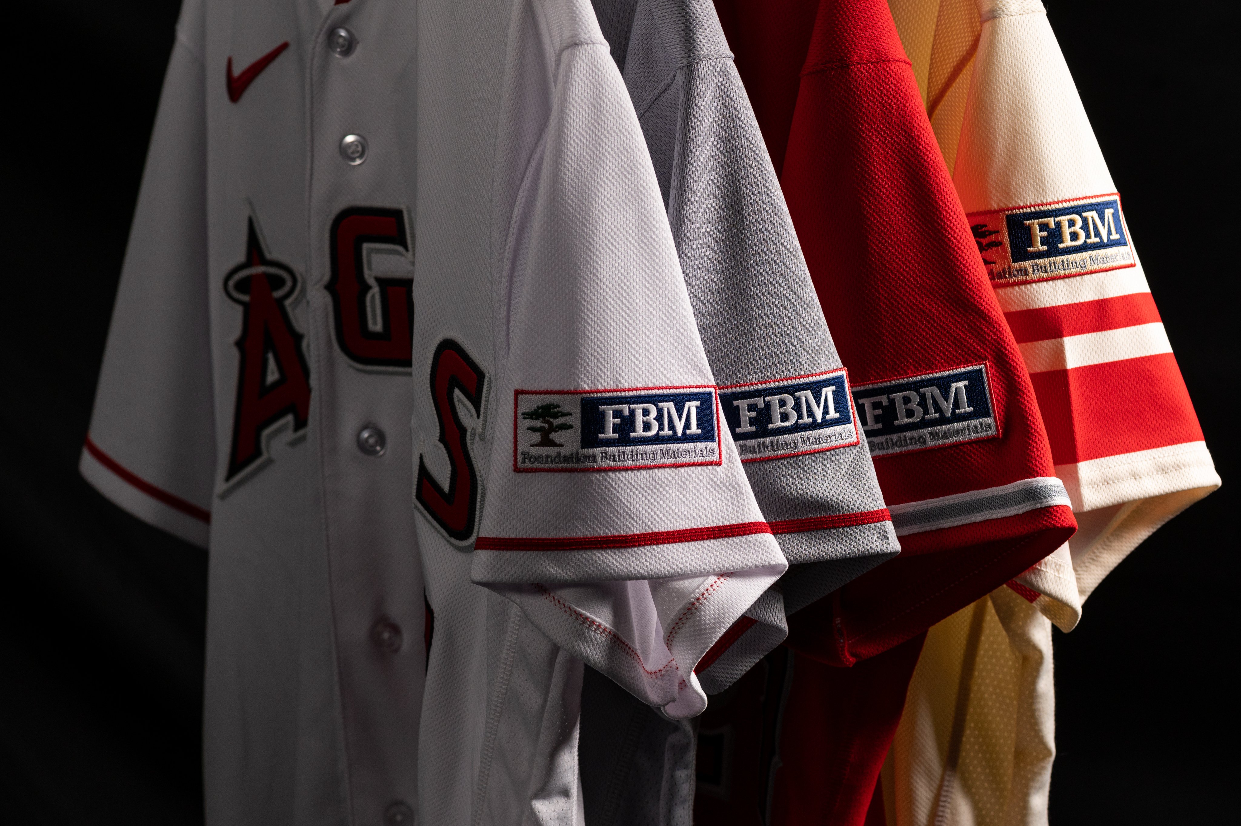 The Angels white, grey, red, and City Connect jersey tops with the Foundation Building Materials logo on each sleeve.