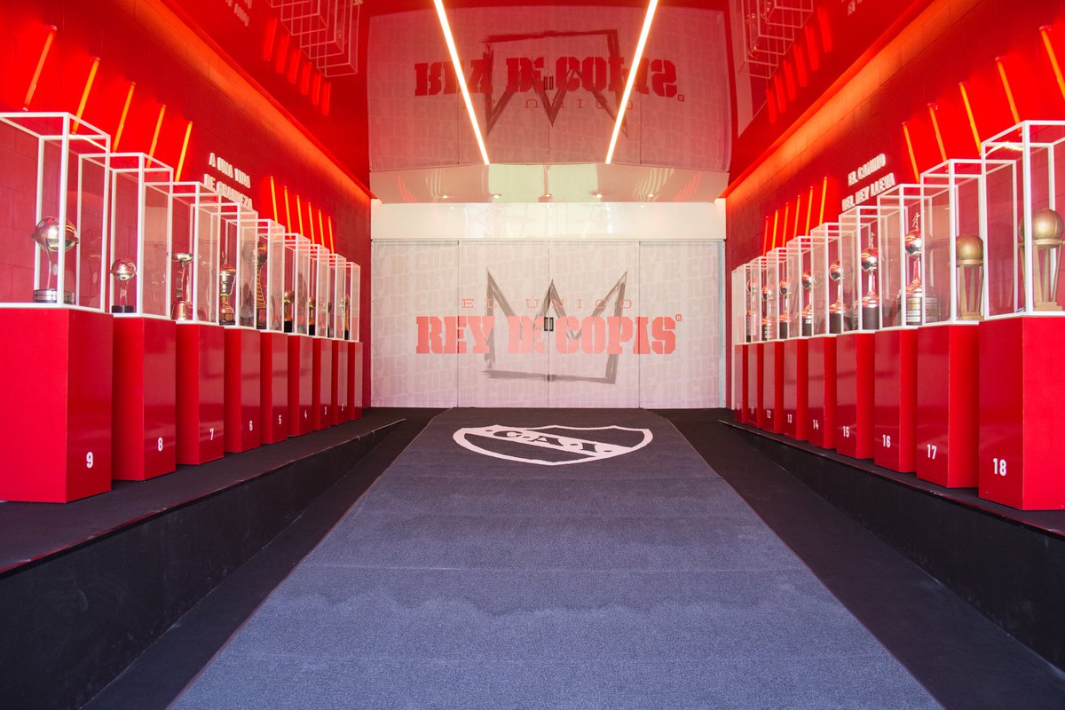 Independiente's tweet photo. Un túnel hacia la gloria, con los trofeos de las batallas que nos trajeron hasta acá.

El camino del Rey lleva a una vida de grandeza solo para quienes están dispuestos a caminar en un sentido: Siempre para adelante.

Bienvenidos al LDA - Ricardo Enrique Bochini🔥

#TodoRojo 🔴 https://t.co/YDPnDYgqIm