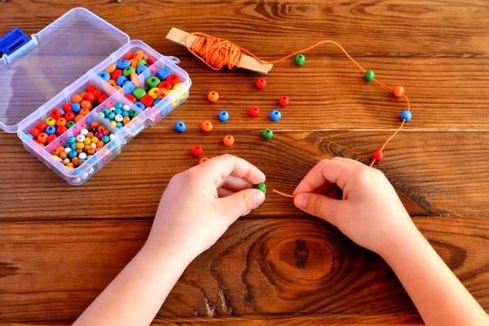 Fine motor skills are key for children to learn how to write and form letters. Putting beads on a string is a tedious task that will improve children's fine motor skills. <a href="/PJLanguageArts/">PJ Language Arts Methodology UWindsor</a>
