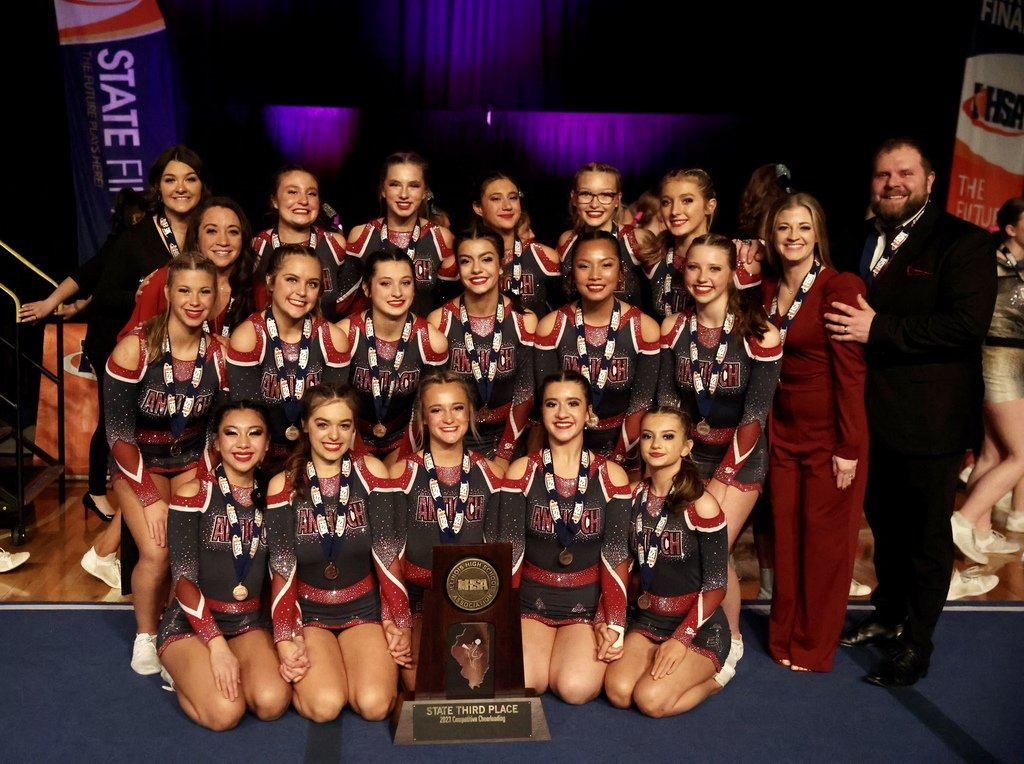 Cheer team pose with trophy.