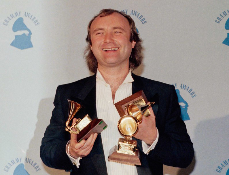 PhilCollinsFeed's tweet photo. A very happy Phil Collins at the #GRAMMYs in 1986, where he won the prestigious Album of the Year trophy for 'No Jacket Required', as well as Best Pop Vocal Performance and Producer of the Year. https://t.co/4zfI3hsClL