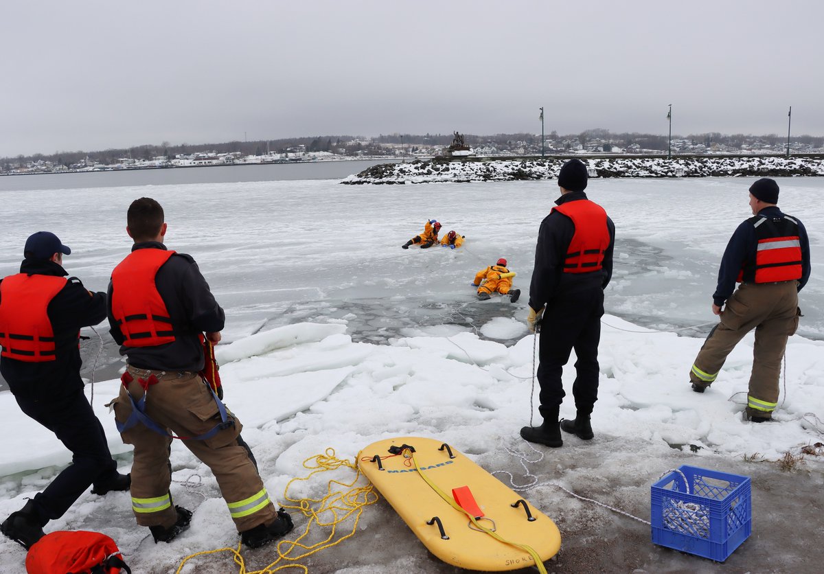 tomayers2262's tweet photo. Cape Breton Regional Fire Service members doing ice rescue training at the marina in Sydney harbour today. Upper right: Scott MacKenzie uses picks to crawl across ice. Bottom left: Matt Wilcox reaches for Jody Wrathall. Bottom right: MacKenzie helps haul Wrathall out. https://t.co/Fjgpkg3zAC