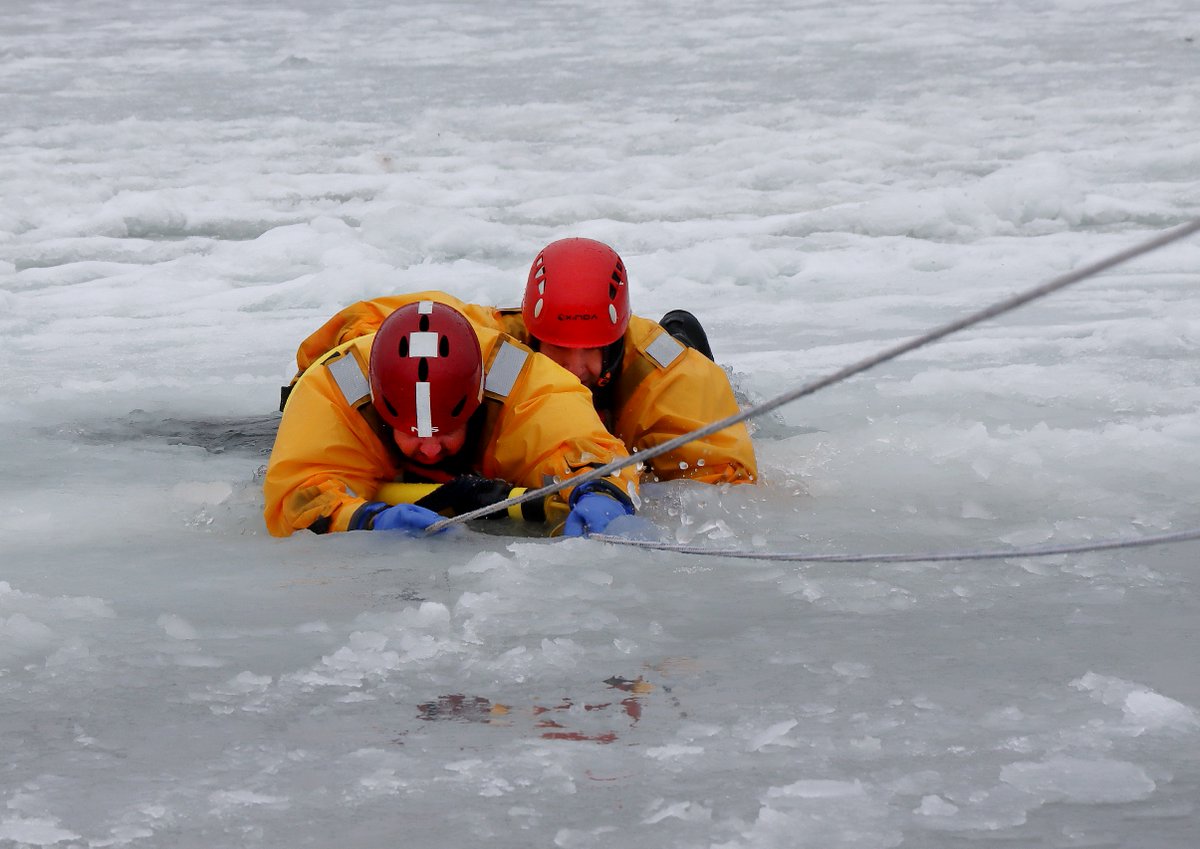 Cape Breton Regional Fire Service members doing ice rescue training at the marina in Sydney harbour today. Upper right: Scott MacKenzie uses picks to crawl across ice. Bottom left: Matt Wilcox reaches for Jody Wrathall. Bottom right: MacKenzie helps haul Wrathall out.