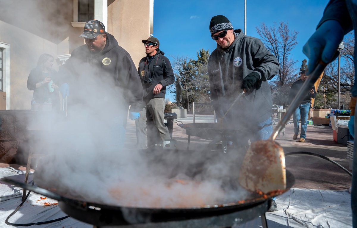 Moises Candelaria, left, Victor Gonzales, right, and others from Los Lunas, cook carne adovada outside the Roundhouse as part of Valencia County Day at the Legislature. abqjournal.com/category/legis…