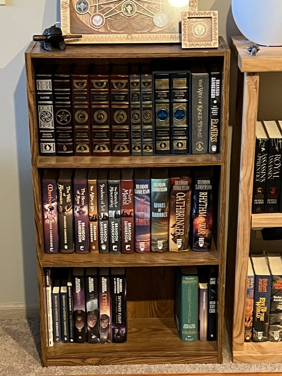 FitzTheListener's tweet image. I finally get to be the one to post their complete leatherbound collection by @BrandSanderson ❤️ only WoA and HoA aren’t signed, but I hope to one day get them signed in person 🥰 my heart, much like my shelf, is full.