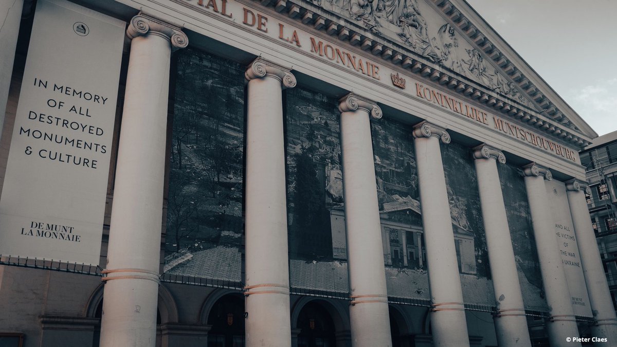 operamagazine's tweet photo. Brussels shows solidarity with Ukraine: at ⁦@LaMonnaieDeMunt⁩, where several initiatives are supporting the victims of war in Ukraine, the facade of the theatre has been adorned with a giant image of the Mariupol Theatre, completely destroyed almost 11 months ago. https://t.co/39fR1LdoAy