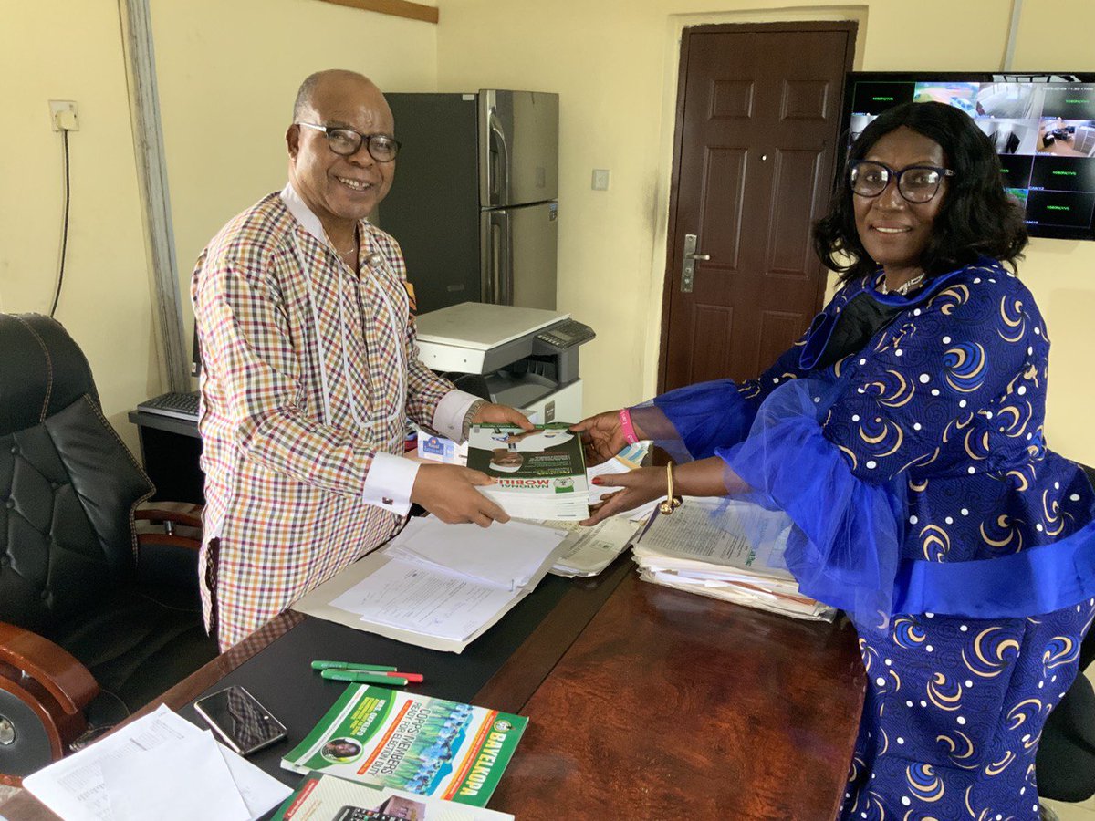 Dr Emmanuel Alex Hart, REC INEC Bayelsa State being presented with copies of National Mobiliser magazine by Mrs Patricia Maduemezia State Director NOA