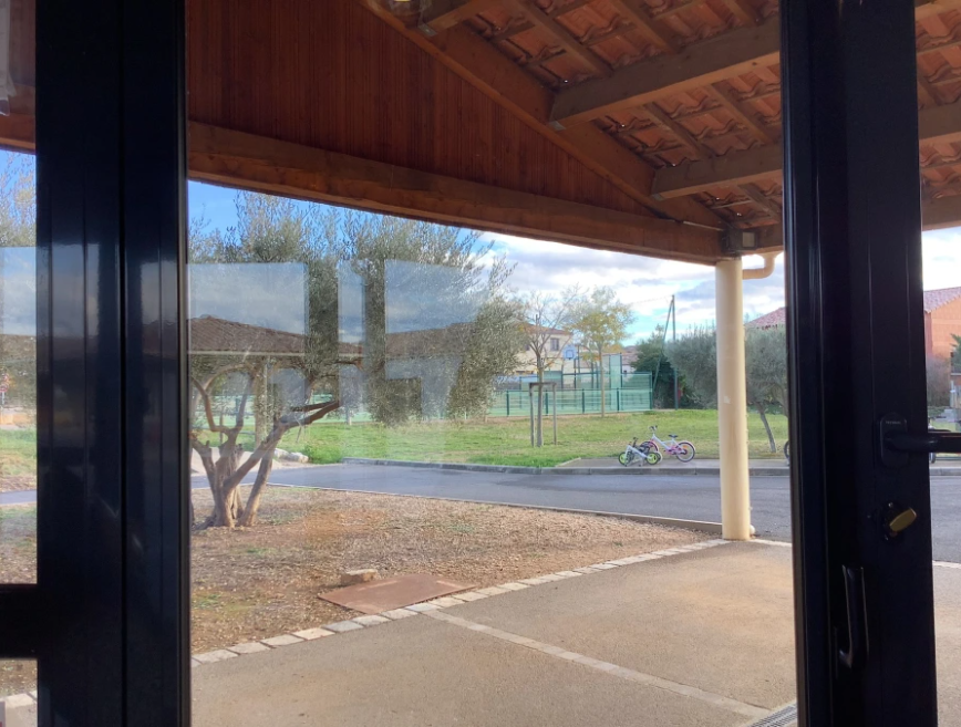 #ParLaFenetre2023 #Twoulipo #EQ34 Par la fenêtre, de beaux arbres fabuleux (sauf un), des vélos merveilleux, des poteaux monstrueux, une plaque d'égout avec des yeux, du béton noir reflets bleus, avec un toit légèrement vieux. Que de sentiments heureux!