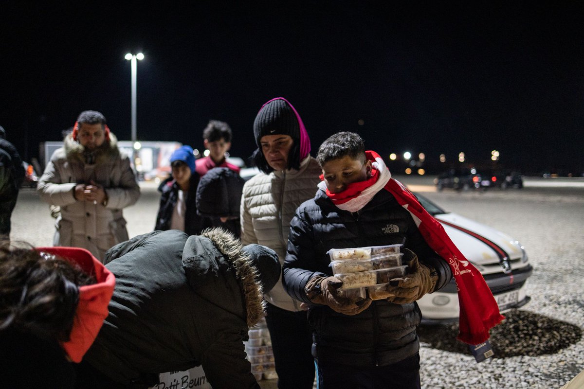 WCKitchen's tweet photo. The quakes destroyed thousands of buildings &amp; left thousands more unsafe to inhabit. WCK delivered meals at a parking lot in İskenderun where hundreds of people are spending the night. Families—many with small kids—huddle around fires for warmth &amp; sleep in cars. #ChefsForTürkiye https://t.co/KfRvHnoAaD