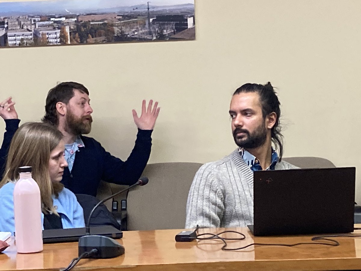 Christopher Sweeney presenting his research on who migrants in Glasgow go to for help when child is sick, discussed vividly by the audience