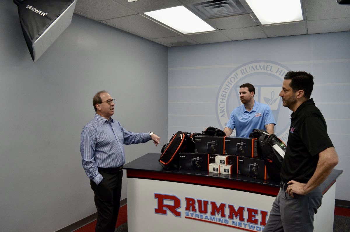 ArchRUMMEL's tweet photo. We had a special guest stop by this week, Rummel Alumnus Michael Hebert ‘78. 

Mr. Hebert, who is the Director of Photography for the New Orleans Saints, made a personal donation of cameras and equipment for our student photographers. 

Thank you, Mr. Hebert! #RummelAlumni https://t.co/5Pugp7Qufn