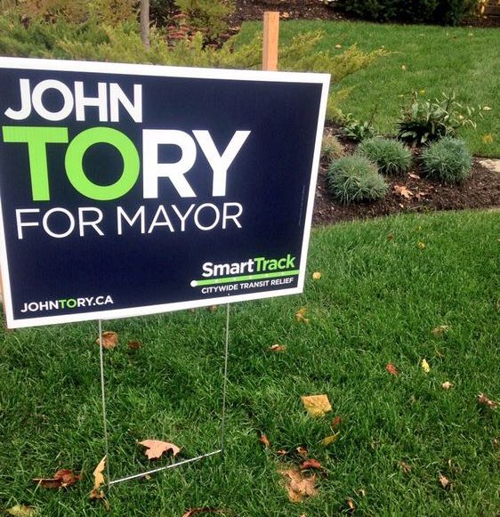 DrKateTO's tweet photo. He put SmartTrack - remember that imaginary transit line?- on his lawn signs. 

John Tory’s legacy will be one of cruelty towards his citizens, crumbling infrastructure, wasting money on a highway during a climate crisis, and transit promises that never came true. #AusterityTO https://t.co/ok8tzcCA0B