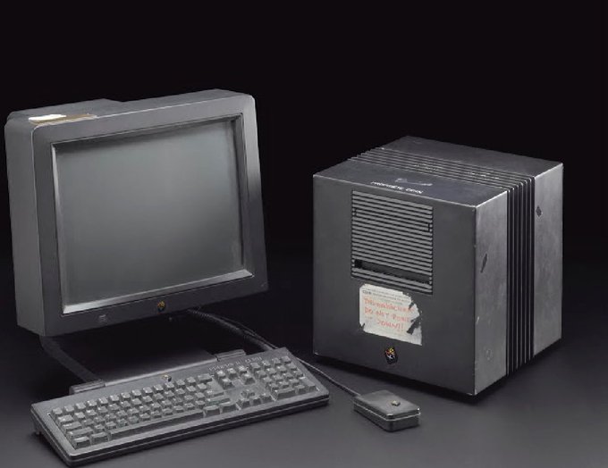 This is the original NeXT computer used by Sir Tim Berners-Lee to design the World Wide Web. Black monitor, mouse and Next computer box in a squared format.