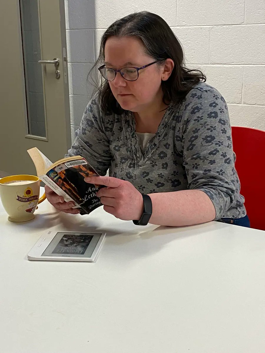 Me in work, on a break, #SqueezeInARead #DublinCityLibraries #BallyfermotLibrary with my library themed mug, a Mills and Boon Historical and a #BorrowBox book on my ereader