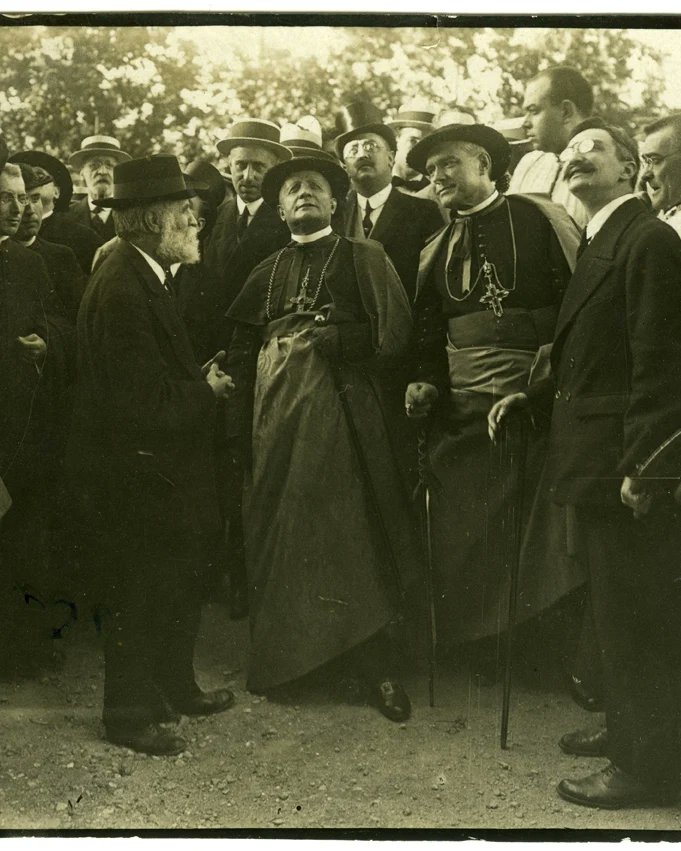 Antoni Gaudí visita les obres de la Sagrada Família. L'arquitecte envoltat de personalitats eclesiàstiques, militars i civils. Tots fent rotllana, escolten les seves explicacions.

 📆 01/01/1903 31/12/1917

 📷 Ballell Maymí, Frederic

<a href="/BCN_arxiu/">Arxiu Municipal de Barcelona</a>

 #gaudi #historiaambcolor