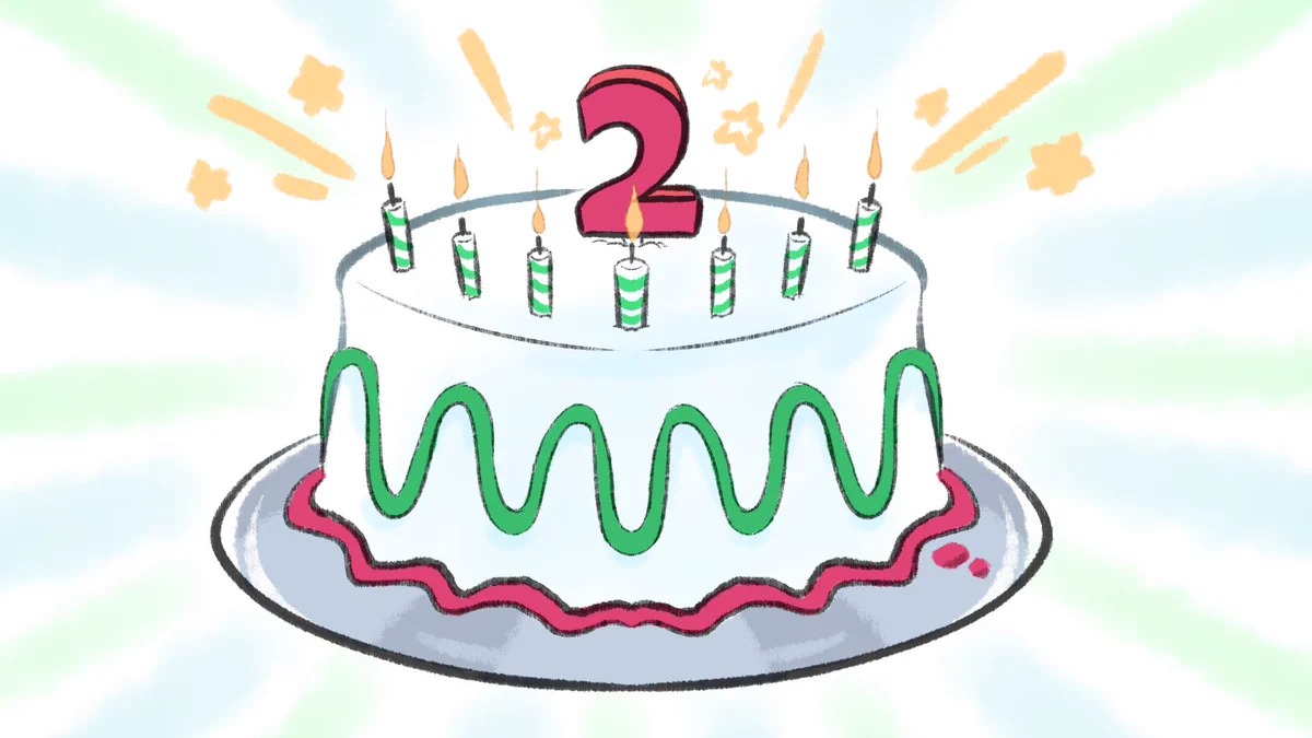 A birthday cake with seven candles and a large, red number two on top.