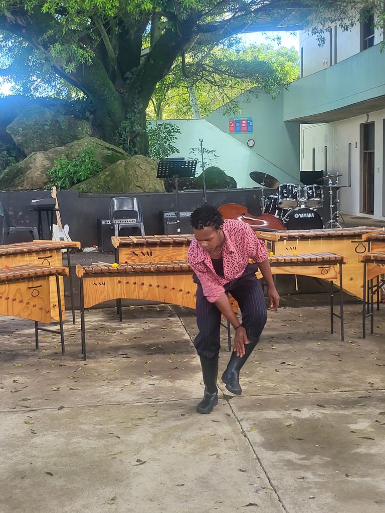 WaterfordUWCSA's tweet photo. Our IB2 student, Lindelwa, playing a gumboot dance as a tribute to outgoing Head of Visual Arts, Ramila Patel.
#FarewellAssembly https://t.co/USSzZCPBE2