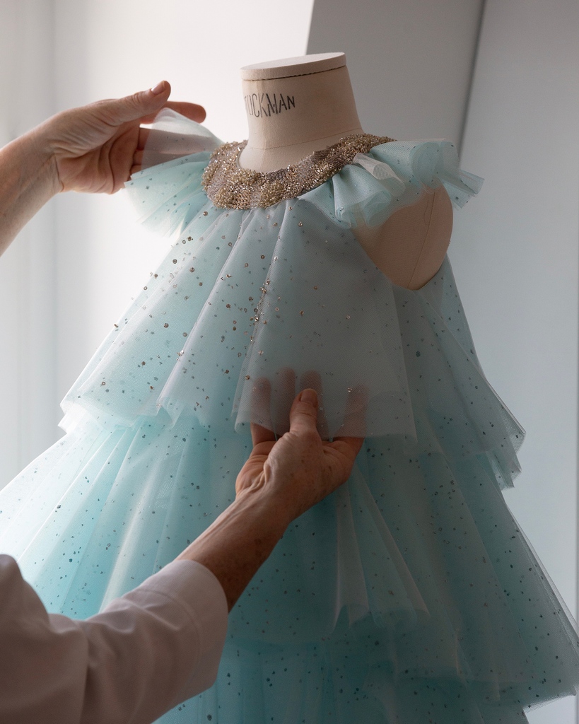 Dior's tweet photo. The excellence of #DiorSavoirFaire is embodied with this whimsical blue cascading tulle #BabyDior dress with flecks of gold sequins and a beaded neckline by Cordelia de Castellane. Discover more on Instagram https://t.co/eScizFV06j! https://t.co/5TUcH2AZoK