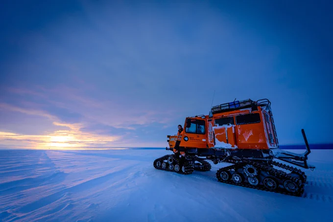 Sno-Cat parked on flat terrain at sunrise