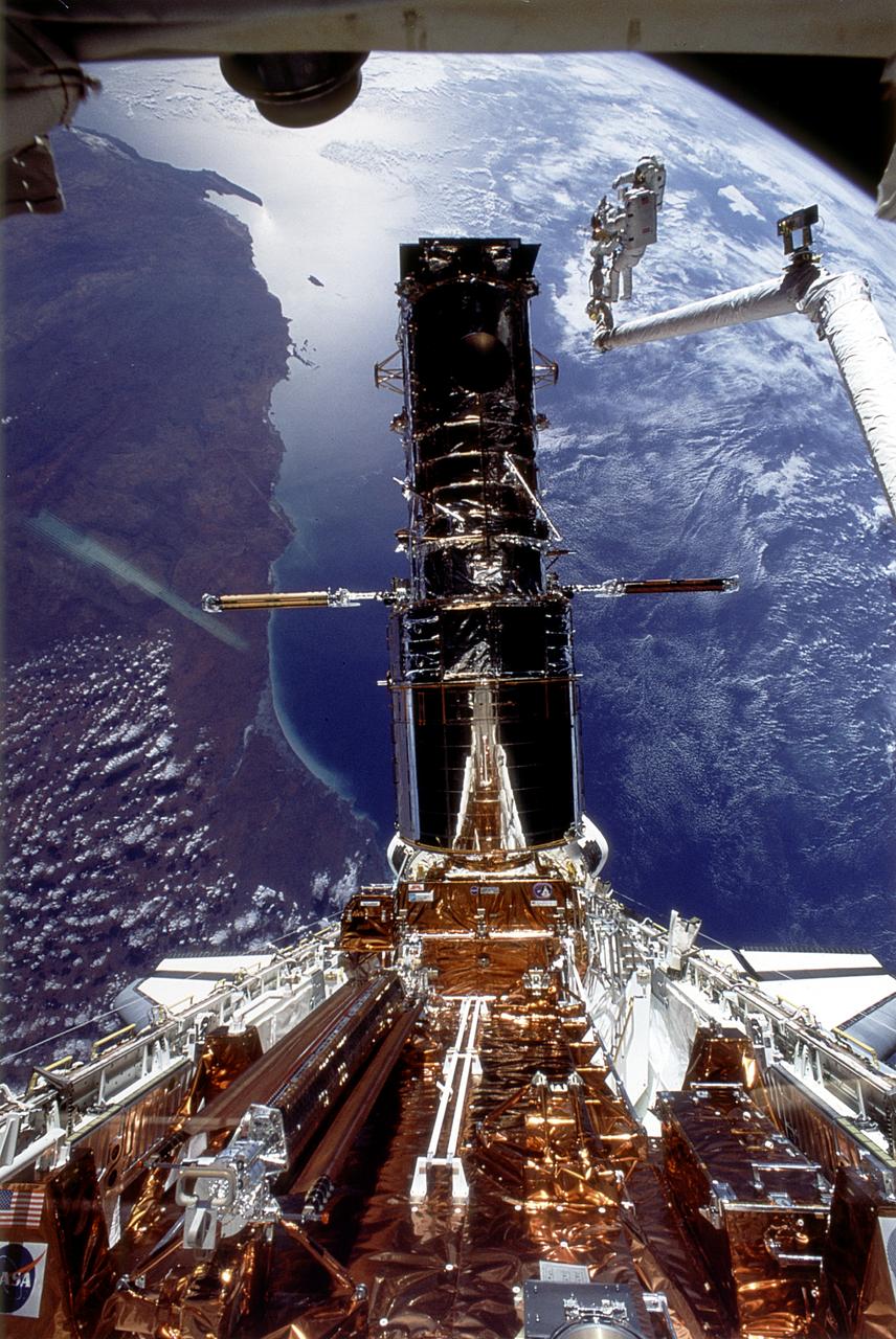 A captured Hubble in the Endeavour's cargo bay, orbiting above the Earth.