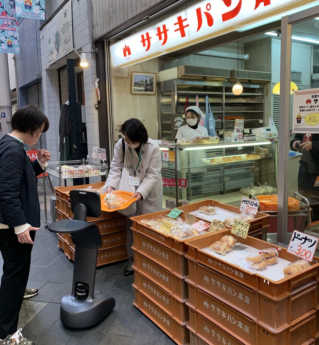 nayamachi's tweet image. 遠隔操作ロボット"Temi"が、、
納屋町商店街に現る！

京都市呉竹総合支援学校高等部の生徒さんが学校から遠隔でロボットを操作、
大手筋商店街を通り、納屋町商店街の
ササキパン本店でパンを購入、
竜馬通り商店街へ抜けていきました！

#temi #遠隔操作ロボット #ロボットでお買い物