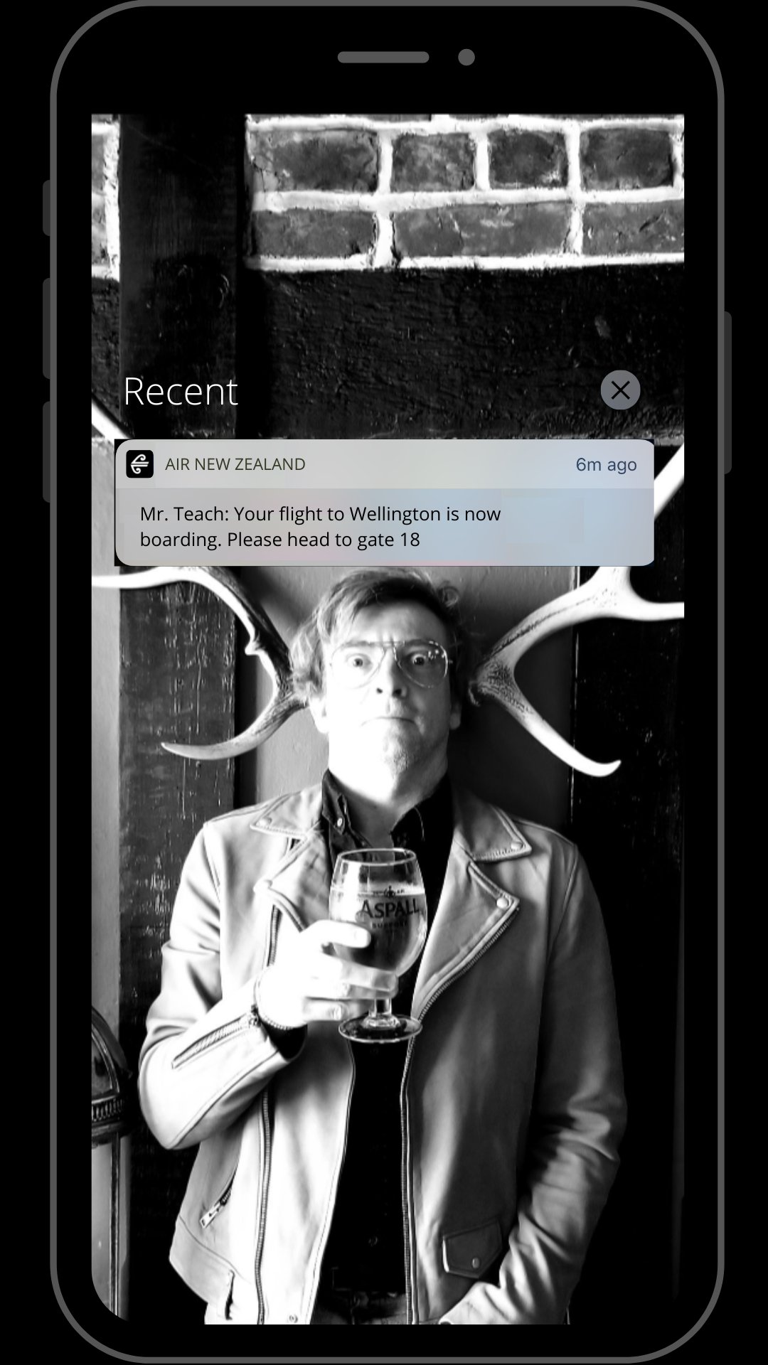 Ed's phone screen. Picture of Stede for the wallpaper. Notification from air new Zealand for boarding a flight to Wellington. 