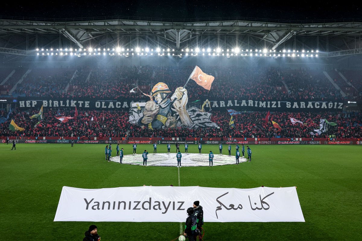 filippothiery's tweet photo. La coreografia dei tifosi del Trabzonspor per i soccorritori del terremoto, compreso il cane Proteo, morto di sfinimento dopo aver salvato 2 persone. Lo striscione "staremo insieme, guariremo le nostre ferite" è accompagnato dallo sventolio di bandiere di tutte le squadre turche. https://t.co/Q1eG9OL2BD