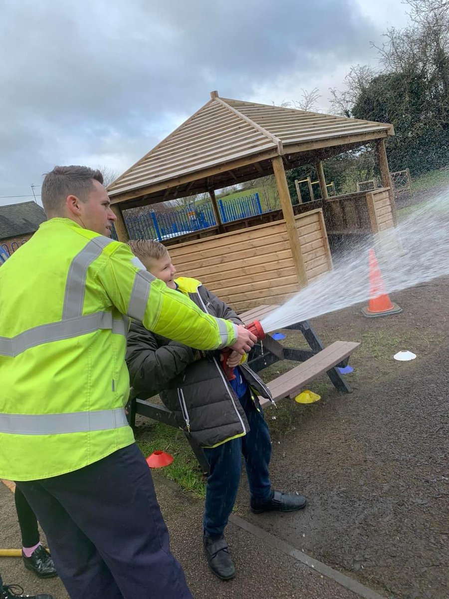 SKprimary's tweet photo. We had the best end of term treat today - a visit from Lutterworth Fire Station.🤩 They gave a great assembly where Miss Bulmer was invited to try on all their equipment! They also spoke on the importance of having smoke alarms fitted and having an evacuation plan. #firesafety https://t.co/OXwV2pBXKs