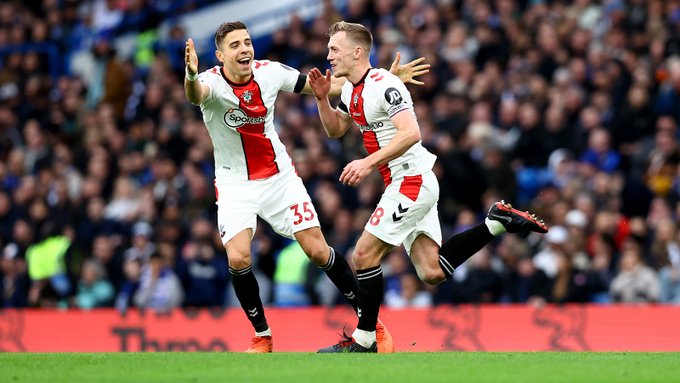 A delighted James Ward-Prowse begins to run back across the Stamford Bridge pitch towards the away fans, as a smiling Jan Bednarek runs towards him.