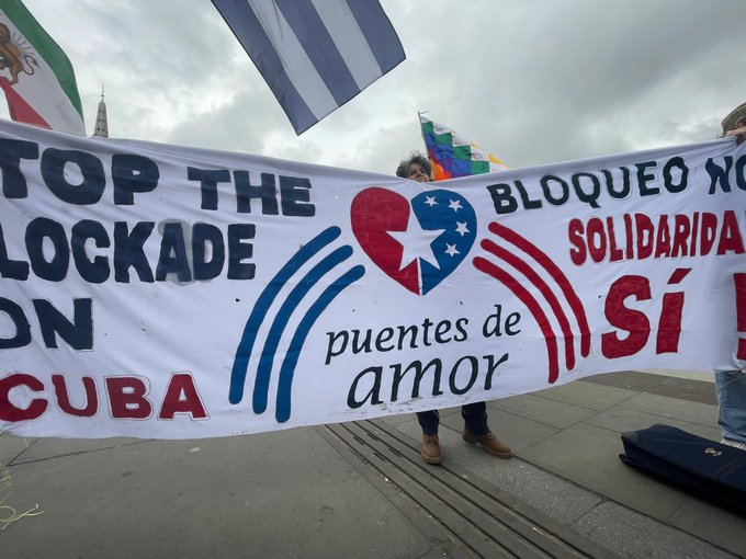 A huge #Cuban flag unfurled in Trafalgar Square this morning. Members of the Cuba Solidarity Campaign and the organization #PuentesDeAmor  raised their voices against the blockade and President Biden's genocidal policies against #Cuba. #JuntosLogramosMas #MejorSinBloqueo