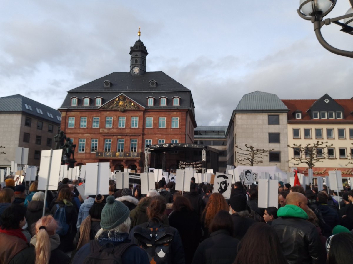 Der Marktplatz in Hanau voller Menschen. Viele halten Schilder mit den Portraits und Namen der am 19. Februar 2020 ermordeten 9 jungen Menschen.