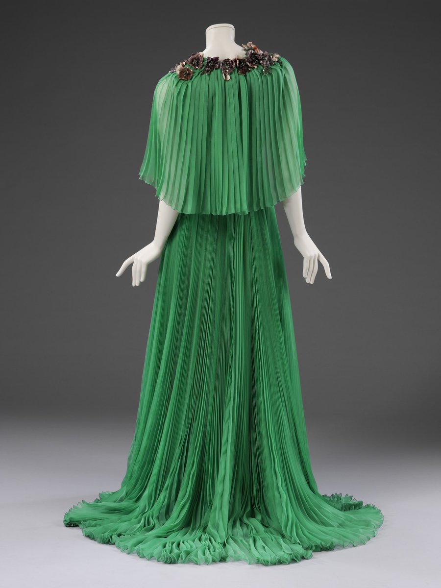 V_and_A's tweet photo. Good evening 🌙 

This floor-length evening gown by Gucci is made of jade green pleated chiffon with hand-painted silk flowers.

Worn by Lupita Nyong’o at Cannes Film Festival in 2015 🎥 https://t.co/dnlqcKlbAH