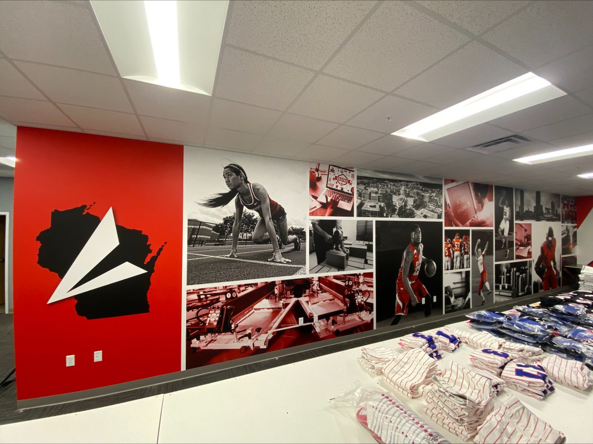 Our graphic artist Kaitlyn took some boring gray walls and brought them to life at the BSN Sports Waunakee office! 🤩 Contact us today to order your wall murals for your school or office! #fanaktivemarketing #wallmurals #largeformatprinting @BSNSPORTS