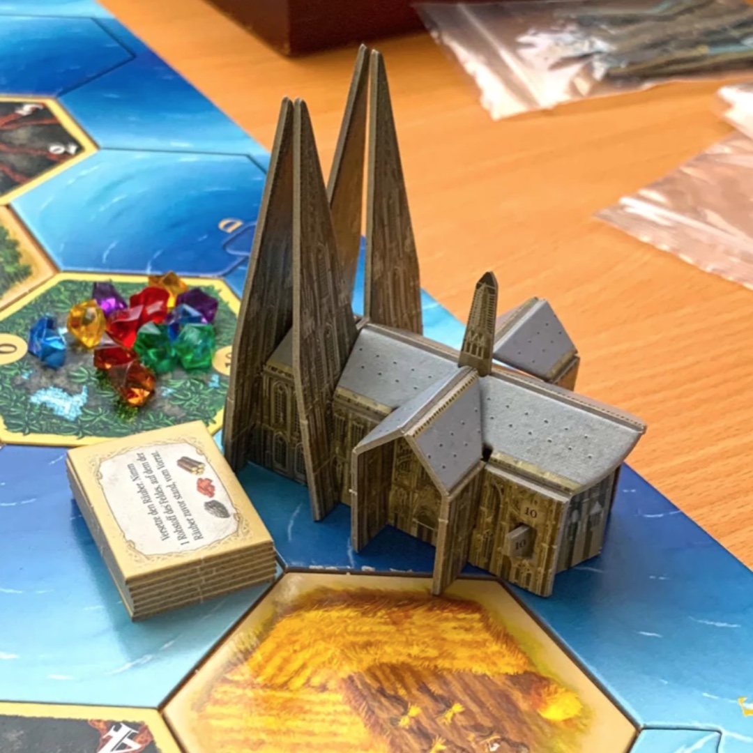 What are you doing Saturday night? How about a beer and a round of CATAN at our Saturday evening Spieleabend? All players get a Cologne Cathedral mini add-on created for the 2018 World Championships. $10 includes a beverage and snacks. Register at bit.ly/41o5M2p