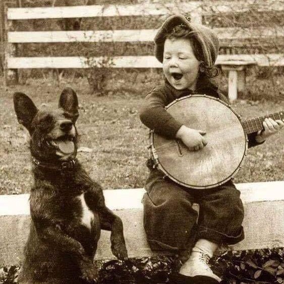 historydefined's tweet photo. A young boy playing the banjo with his dog, 1920. https://t.co/bO2YZuXpBk