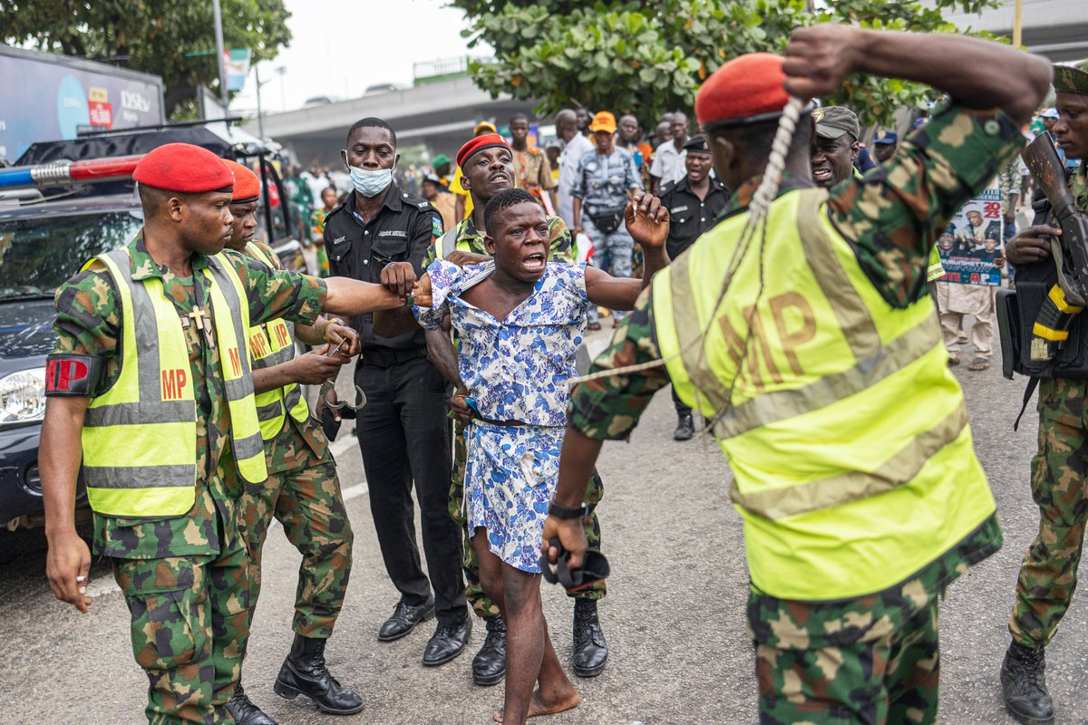 channelstv's tweet photo. Members of the Nigerian Army Military Police detain a man suspected of smoking illegal substances during the rally for APC presidential candidate Bola Ahmed Tinubu at Teslim Balogun Stadium in Lagos ahead of the Nigerian presidential election. (Photo by Michele Spatari / AFP) https://t.co/mWdSE7qrDh