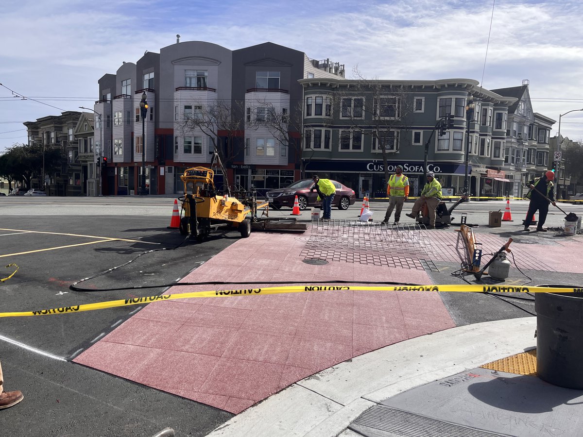 A brick-like paving treatment is being added to the crosswalk at Sanchez &amp; Market &amp; 15th Streets. 

The bricks are made by melting colored asphalt squares with a metal template overlay into fresh pavement with a blow torch machine. The stencil gets rolled back showing the design.
