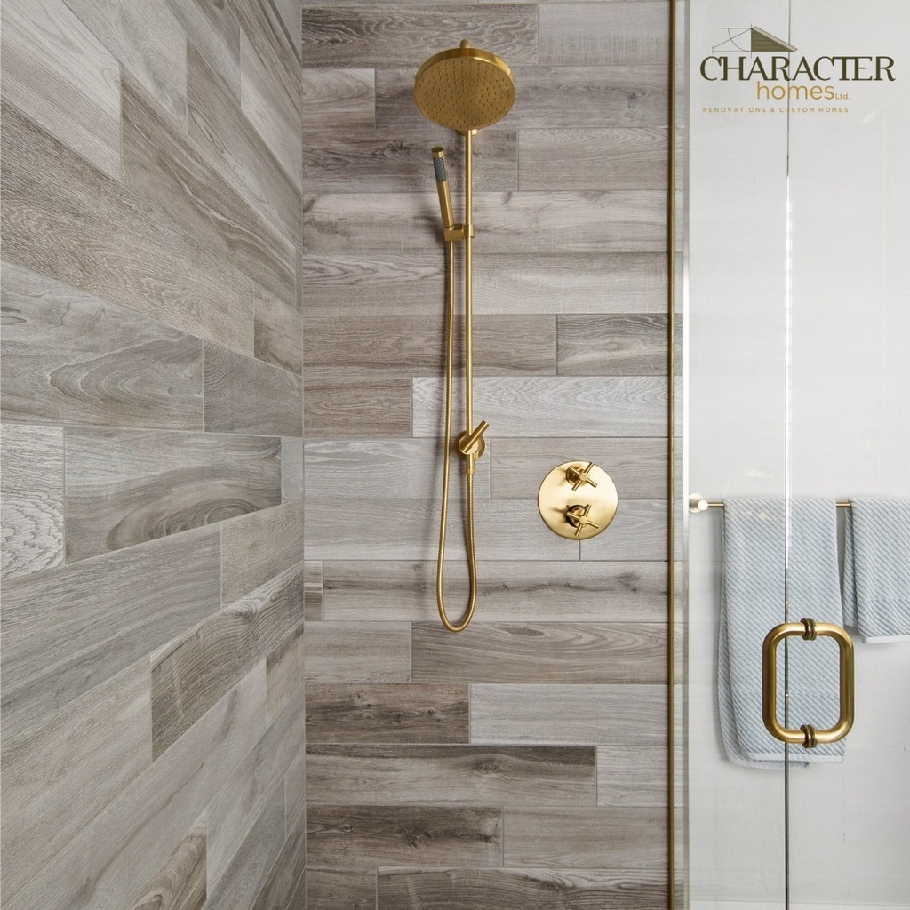 This custom shower just got even better with the addition of glass doors, stunning custom tile and luxurious gold hardware. It's the perfect place to start and end the day. #customshower #glassdoors #customtile #Home Builder #Custom Homes #HomeReno #bathroomrenovation #luxury
