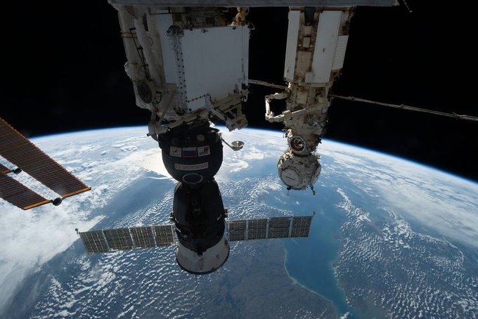 The Soyuz MS-22 crew ship is pictured in the foreground docked to the Rassvet module as the International Space Station orbited 264 miles above Europe. In the background, is the Prichal docking module attached to the Nauka multipurpose laboratory module. They are pointed downward at Earth below. The planet's curvature dominates the image. The background is the blackness of space. Credit: NASA