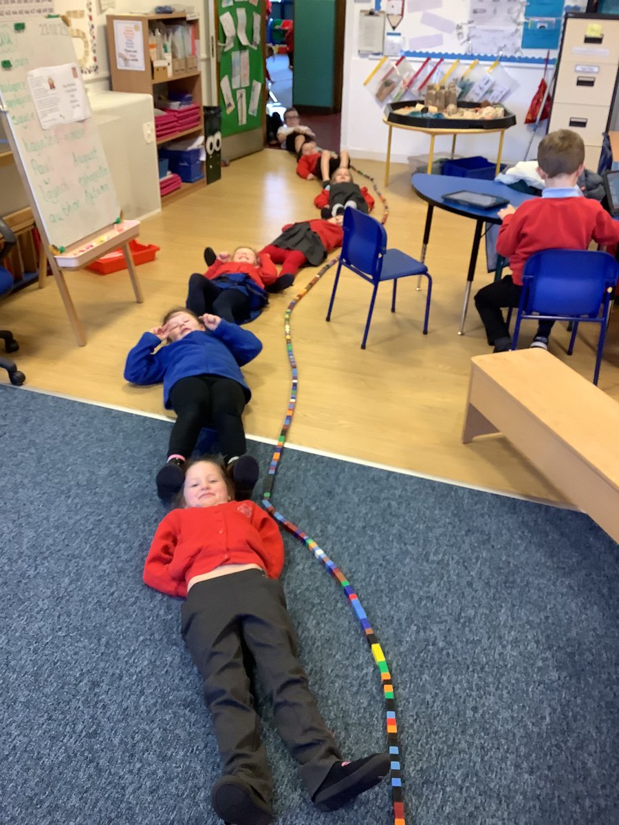 P2 made a very long snake today with their maths cubes going from P2B into P2W. Mrs Warden got a big surprise! 🐍😮They decided to measure how long it was using children. It was 13 children long!#mathsplay