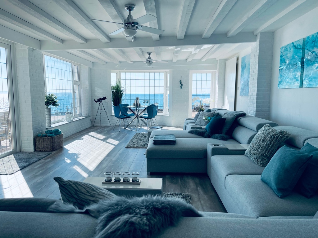 The main living space has large comfy sofas, great sea views and backs into the snug – a cosy room with bean bags sat around a rustic fireplace. #lovebeachhouse45 #staycation #ukstaycation #beachhouse #ukholiday #holidayhome #holidayrental #sussexcoast #seaside