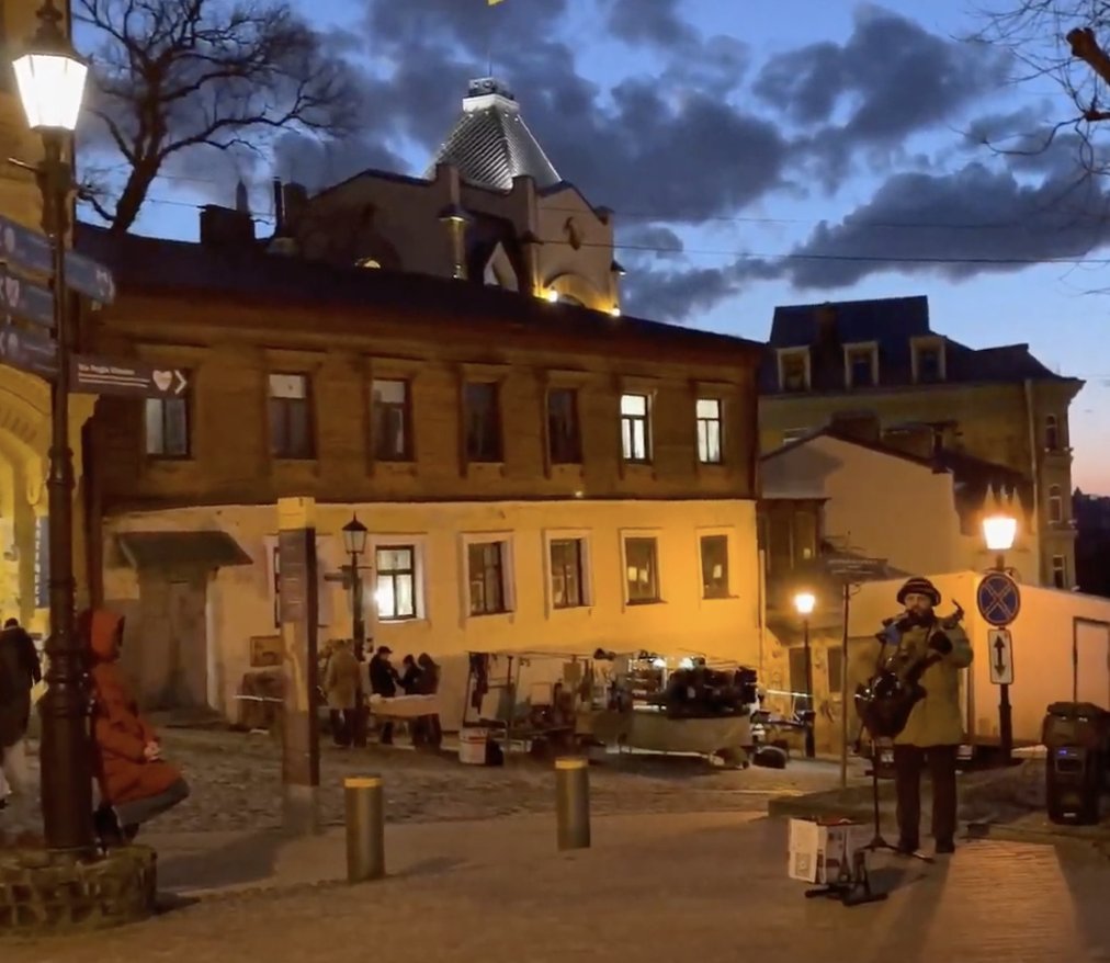 pmarsupia's tweet photo. Hace exactamente un año. 

Una chica de abrigo rojo, apoyada en una farola de la cuesta de San Andrés de Kiev.  Perdida en la música de una guitarra.

Aquel fue el último atardecer de otro mundo. A la mañana siguiente, esta era una ciudad en guerra. (Hilo/🧵) https://t.co/VKOs5mAWsl
