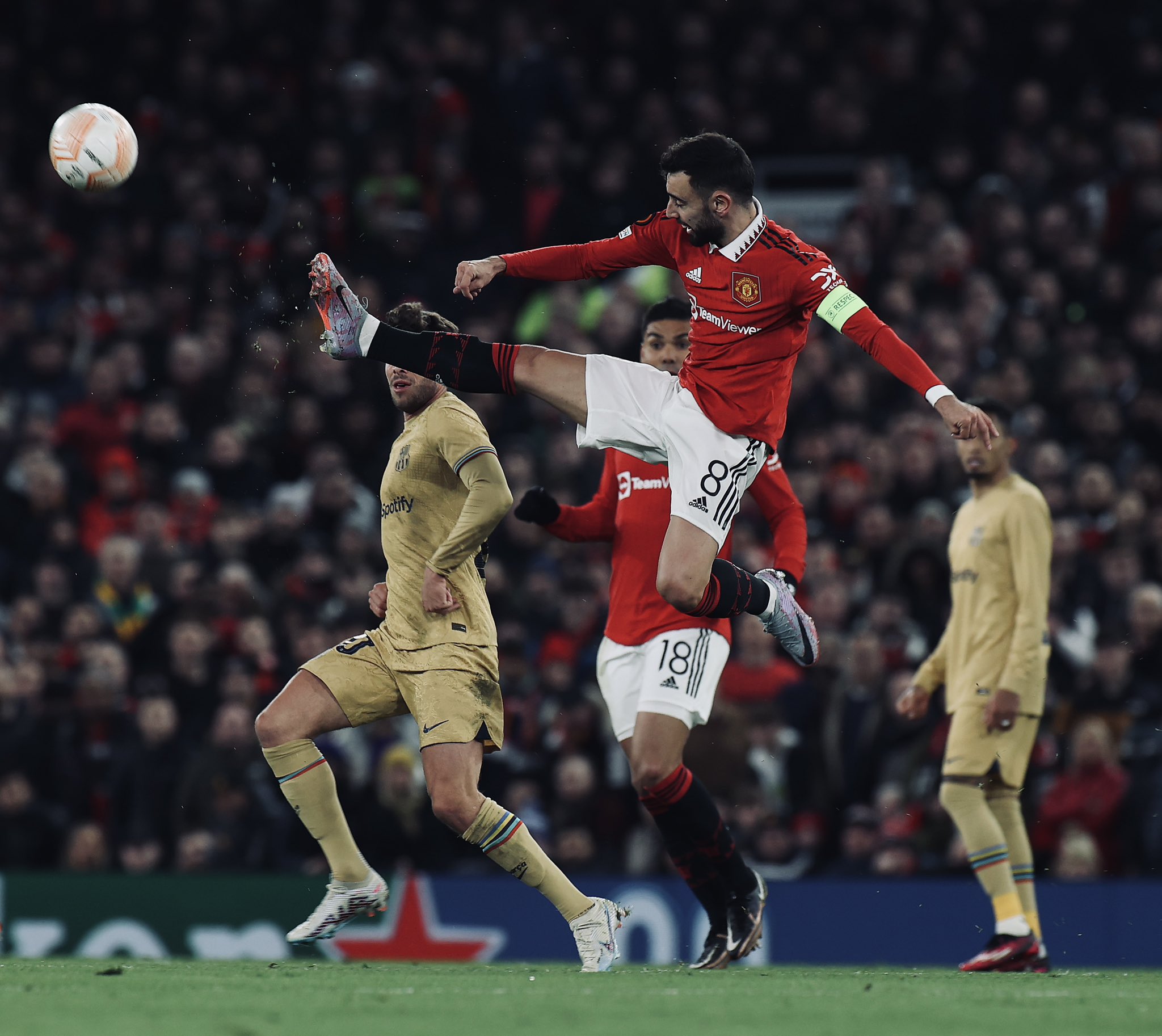 Bruno Fernandes flies into the air, leading with his right foot to get hold of the ball.